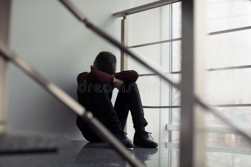 Upset preteen boy sitting on staircase