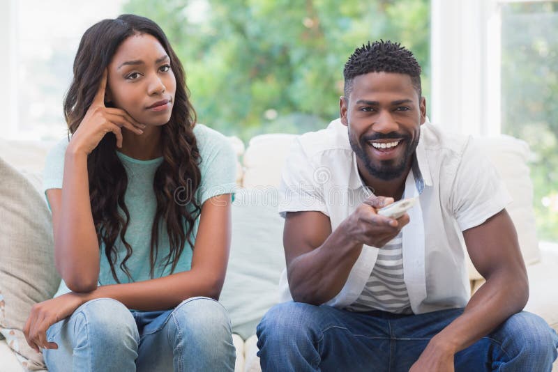 Upset women being ignored by partner at home in the living room. Upset women being ignored by partner at home in the living room