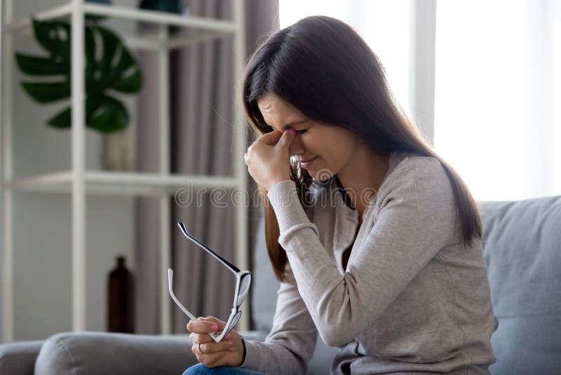 Upset woman taking off glasses, suffering from eye strain