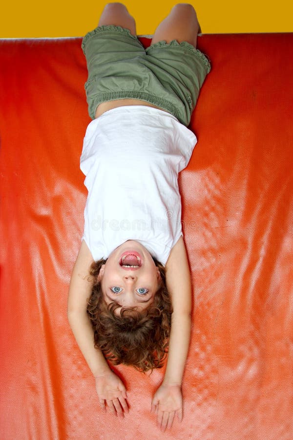 Upside down little girl on slide laughing royalty free stock images Upside down little girl on slide laughing royalty free stock images