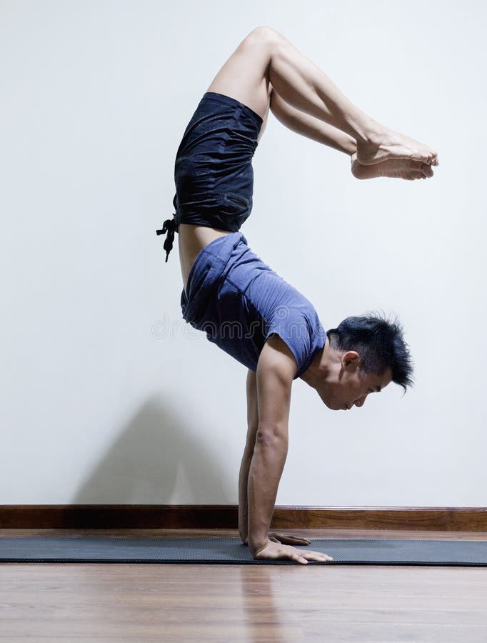 Upside Down Man Doing Yoga in a Yoga Studio, Side View Stock Photo