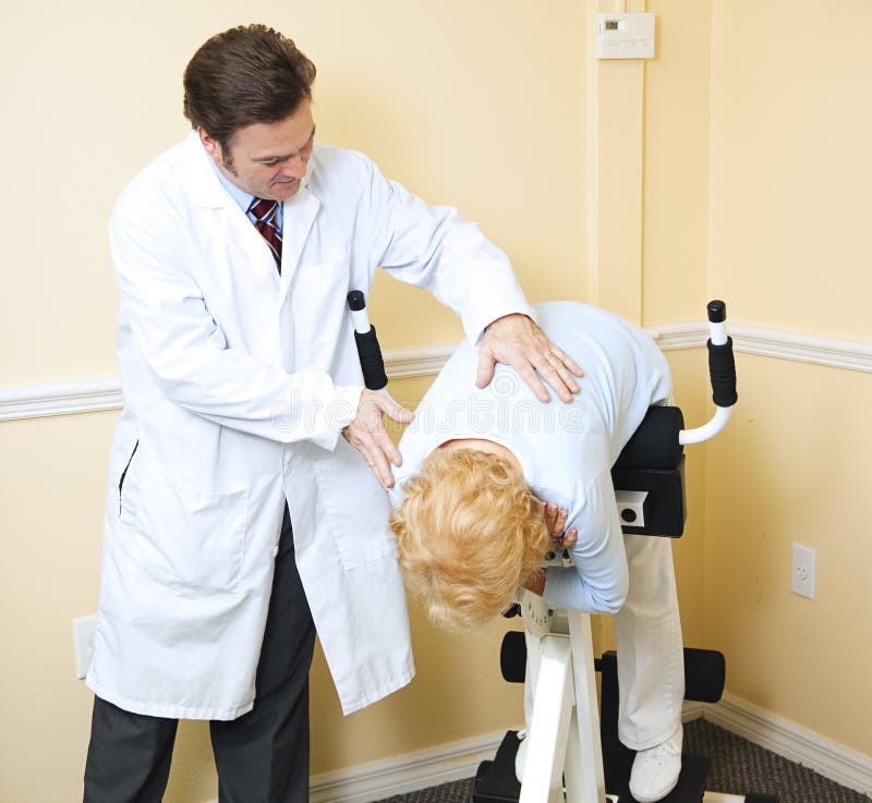 Chiropractor assists an elderly patient recovering from a back injury. Chiropractor assists an elderly patient recovering from a back injury.