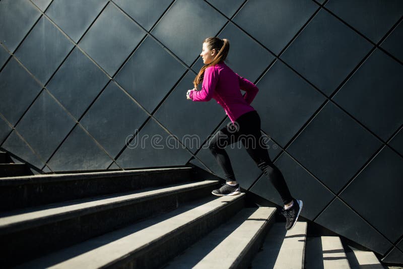 Urban run. Female athlete running fast up the stairs. staircase workout