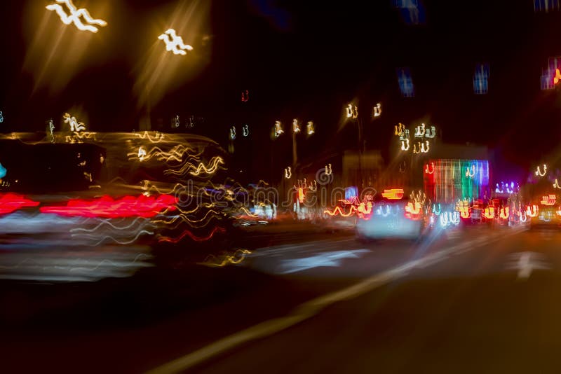 Urban street night traffic with bokeh lights. Blurred auto with bright brake lights, city street lights and speed