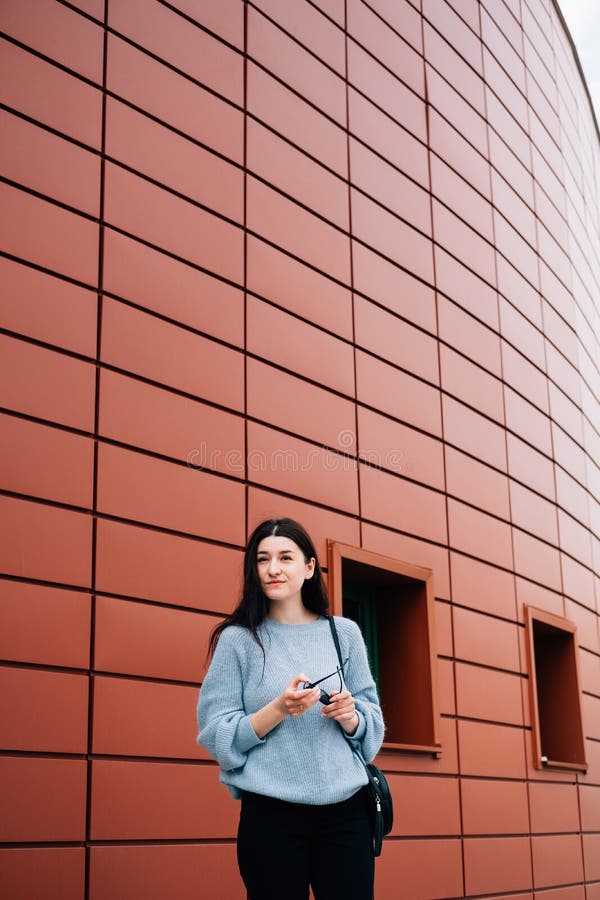 Urban style concept. Portrait of fashionable teenage girl with sunglasses in her hands posing on city street in summer. Glamour stock images Urban style concept. Portrait of fashionable teenage girl with sunglasses in her hands posing on city street in summer. Glamour stock images