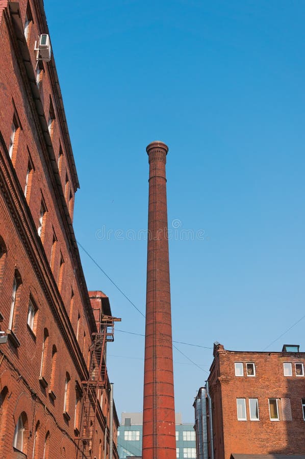 Urban view - factory pipe and old brick buildings against the blue sky stock images Urban view - factory pipe and old brick buildings against the blue sky stock images