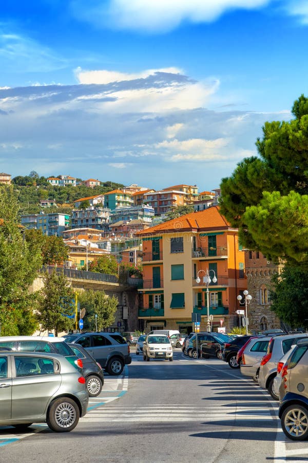 Midday urban landscape of the commune of Celle Ligure against a blue sky with car parking and urban areas. L.go Giovanni Giolitti, Celle Ligure, Savona, Italy. Midday urban landscape of the commune of Celle Ligure against a blue sky with car parking and urban areas. L.go Giovanni Giolitti, Celle Ligure, Savona, Italy