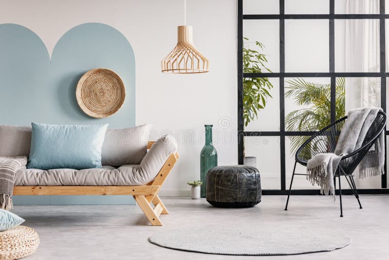 Urbaniseringsdjungeln i ljust vitt och blått levande rum inåt med skandinaviskt futon royaltyfri bild