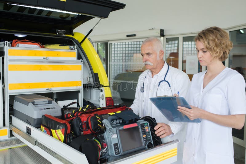 Urgency doctors checking first aid kit box with medical equipment royalty free stock photography Urgency doctors checking first aid kit box with medical equipment royalty free stock photography
