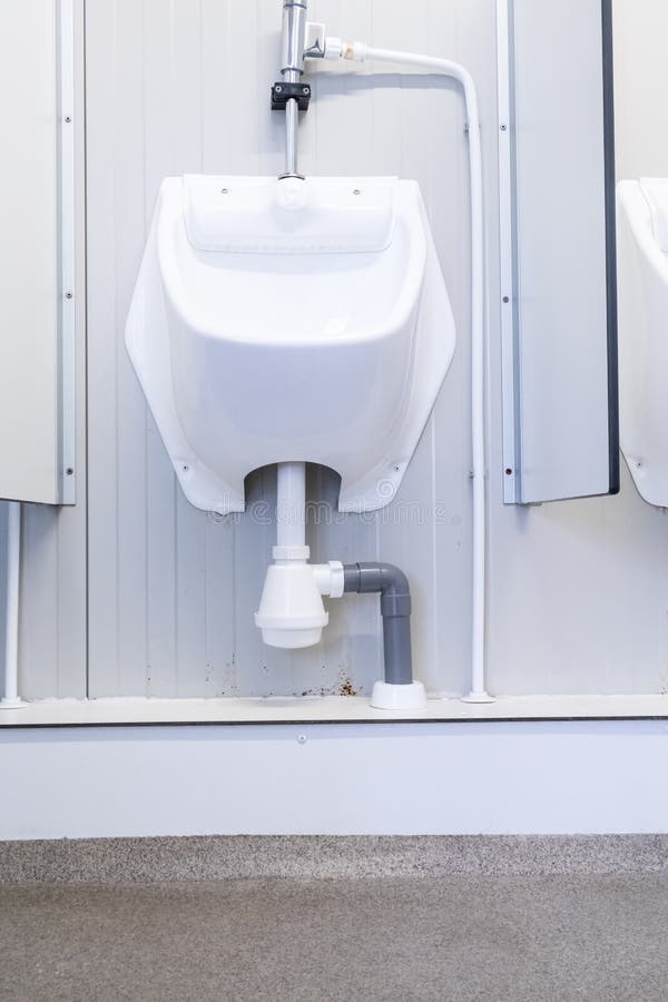 Two Urinals Next To Each Other with a Seperator in between Stock Image