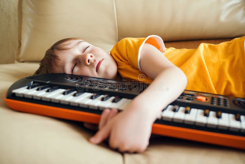 Urocze dziecko zmęczone nauką gry w syntezator. hobby i wypoczynek dla dzieci. przyszły zawód