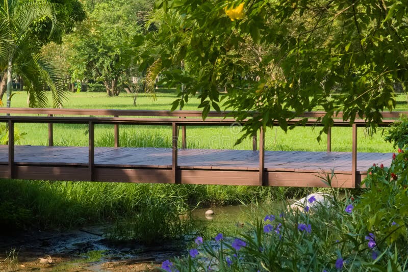Uroczy pokojowy widok parkowy most, rozciąga się małą zatoczkę, i otaczający luksusowym ogródem