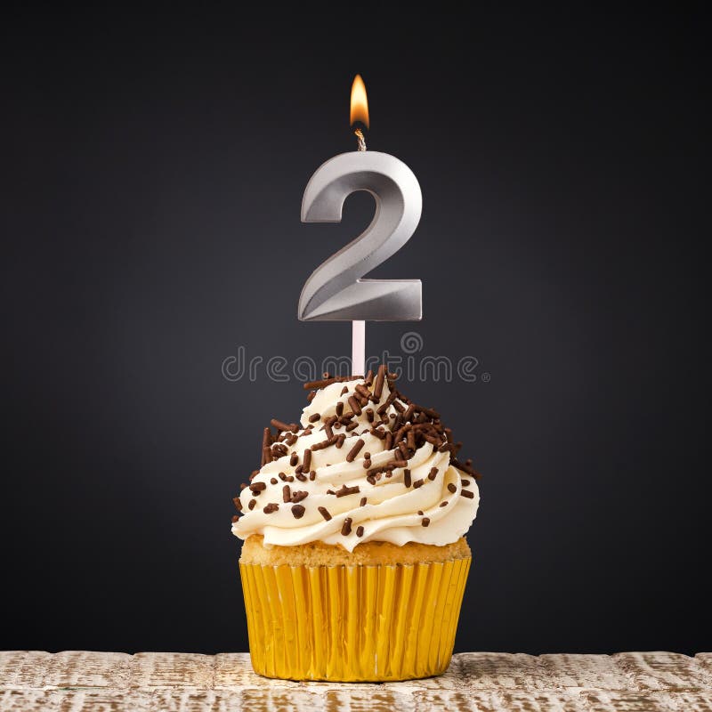 birthday cupcake with number 2 candle - Celebration on dark background. birthday cupcake with number 2 candle - Celebration on dark background