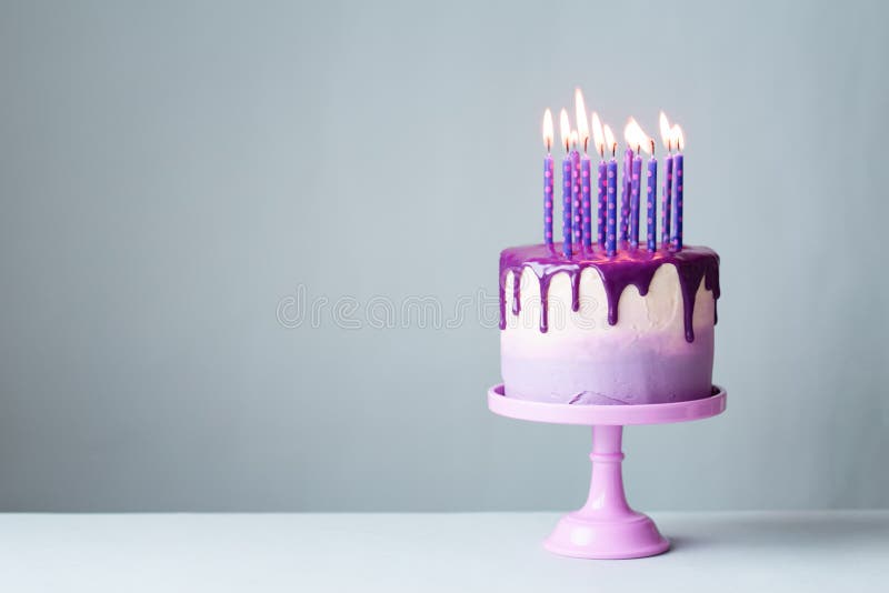 Urodzinowy tort z kapinos purpur i lodowacenia świeczkami zdjęcia royalty free