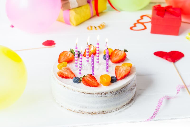 Urodzinowy zdrowy yougurt jagody tort z świeczkami na kolorowym partyjnym tle z jaskrawymi partyjnymi narzędziami, dekoracja, gef fotografia stock Urodzinowy zdrowy yougurt jagody tort z świeczkami na kolorowym partyjnym tle z jaskrawymi partyjnymi narzędziami, dekoracja, gef fotografia stock