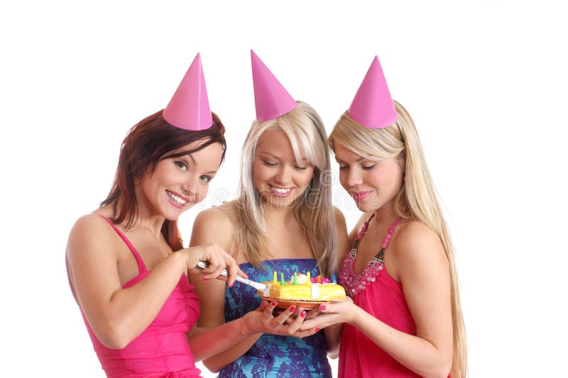 Three young and attractive girls celebrate a birthday party with a cake. Image isolated on a white background. Three young and attractive girls celebrate a birthday party with a cake. Image isolated on a white background.