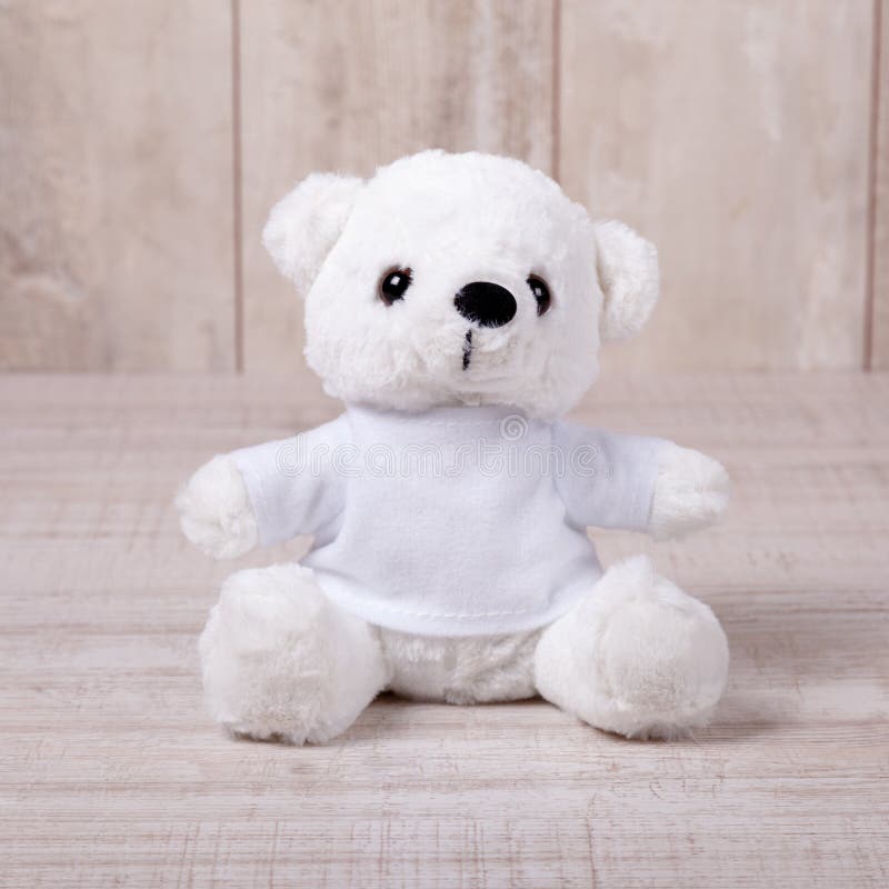 Urso de peluche bonito que senta-se no fundo de madeira velho imagem de stock royalty free Urso de peluche bonito que senta-se no fundo de madeira velho imagem de stock royalty free