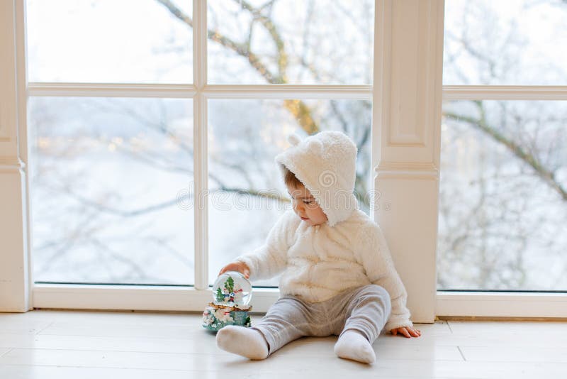 Urso de peluche branco da roupa adorável pequena do bebê do menino que senta-se próximo imagens de stock Urso de peluche branco da roupa adorável pequena do bebê do menino que senta-se próximo imagens de stock