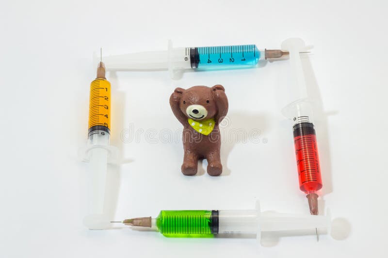 Urso de peluche cozido da argila com as seringas plásticas que contêm soluções multicoloridos fotos de stock royalty free Urso de peluche cozido da argila com as seringas plásticas que contêm soluções multicoloridos fotos de stock royalty free