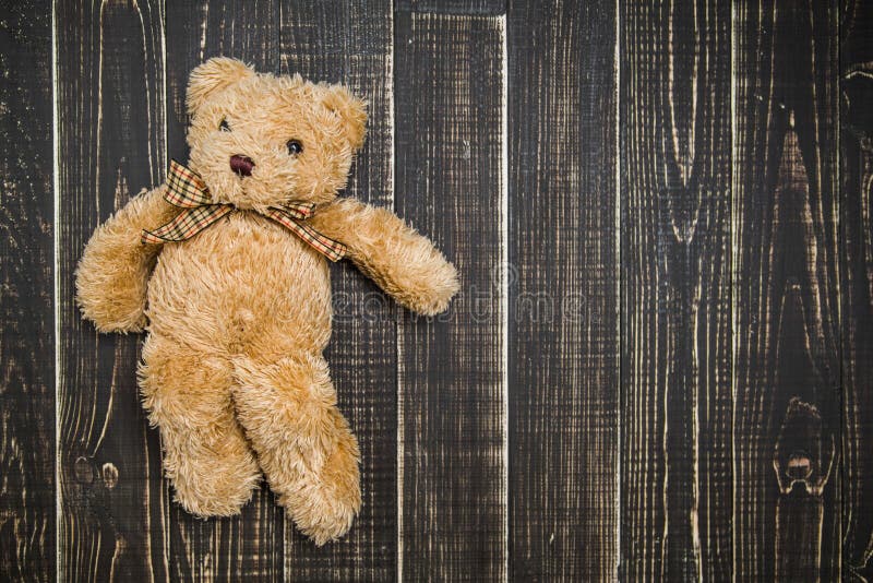 Urso de peluche marrom macio bonito que coloca no fundo gasto de madeira fotos de stock Urso de peluche marrom macio bonito que coloca no fundo gasto de madeira fotos de stock