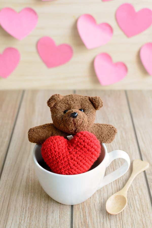 Urso de peluche na xícara de café com forma vermelha do coração na tabela de madeira imagem de stock Urso de peluche na xícara de café com forma vermelha do coração na tabela de madeira imagem de stock
