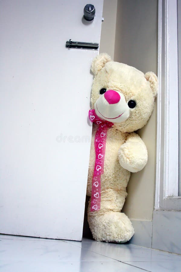 Big teddy bear knocking on the door asking Are you in there?. Big teddy bear knocking on the door asking Are you in there?