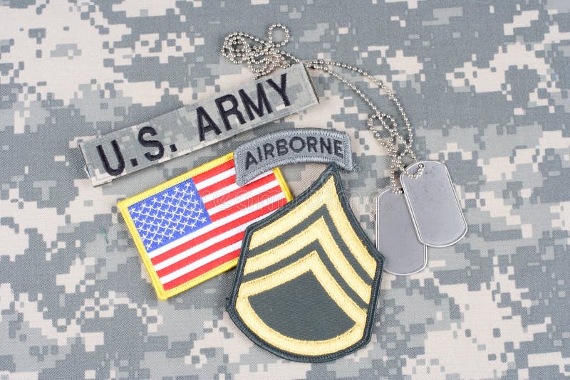 US ARMY Staff Sergeant rank patch, airborne tab, flag patch, with dog tag on camouflage uniform royalty free stock photos US ARMY Staff Sergeant rank patch, airborne tab, flag patch, with dog tag on camouflage uniform royalty free stock photos