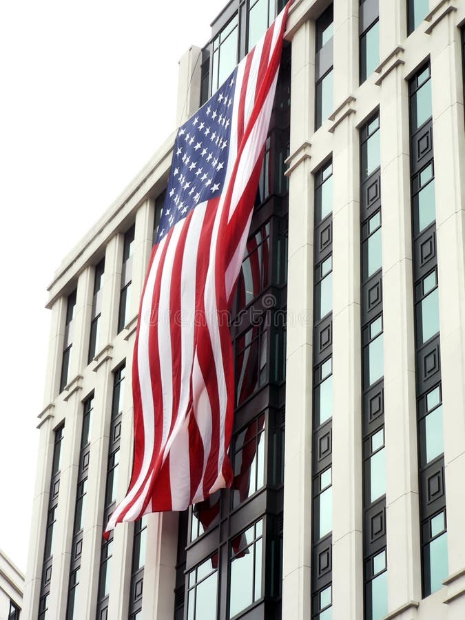 United States flag, hung during a cloudy day, on the front side of buildings in Arlington, VA as a memorial to pay tribute to the victims and heroes of 9-11. United States flag, hung during a cloudy day, on the front side of buildings in Arlington, VA as a memorial to pay tribute to the victims and heroes of 9-11.