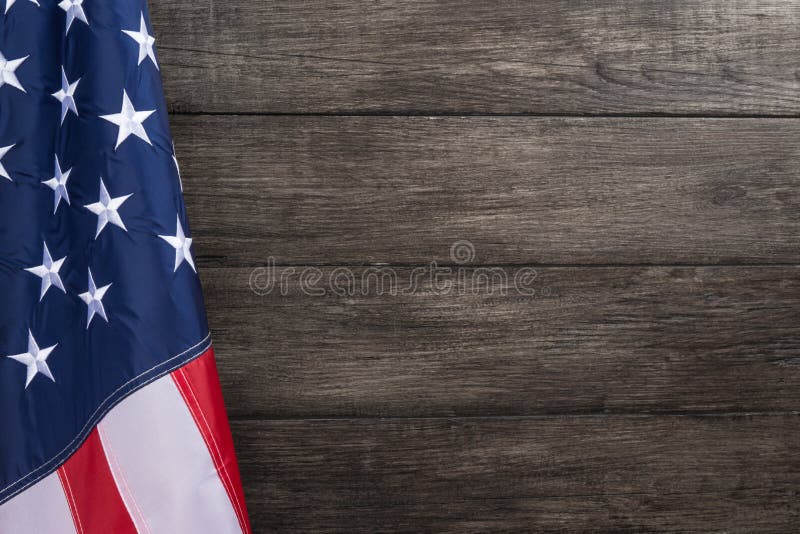 US flag with embossed stars, hanged against wooden wall background