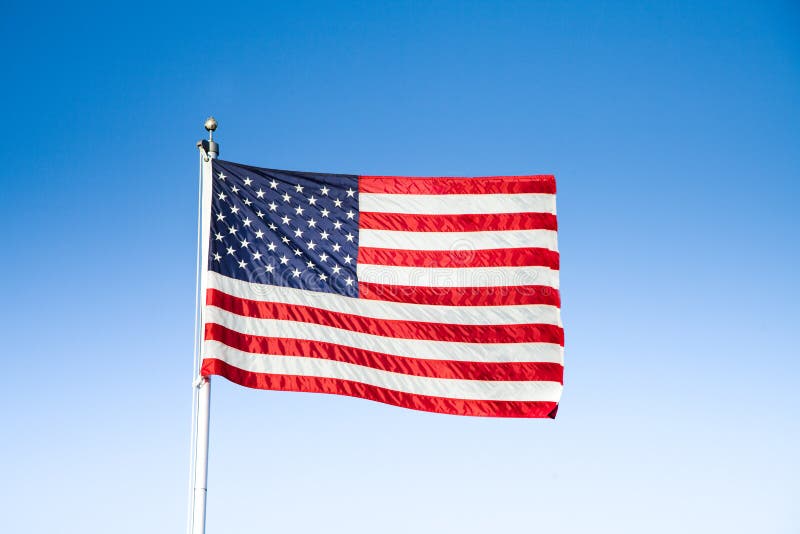 Clásico de Estados Unidos de América bandera ondulación en viento contra cielo azul sobre el hermoso soleado en el verano, unido Estados de, norte.