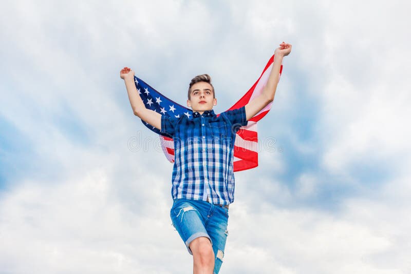 USA flaga trzyma dzia?aj?cym facetem w tle lata niebo zdjęcia royalty free USA flaga trzyma dzia?aj?cym facetem w tle lata niebo zdjęcia royalty free