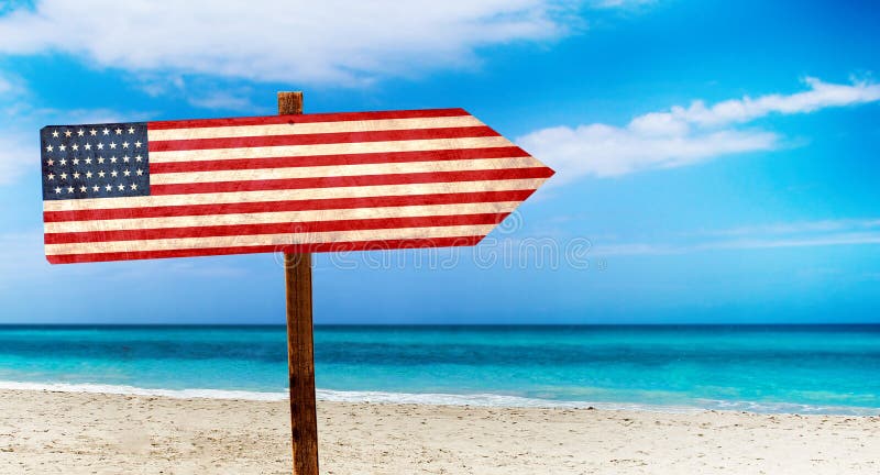 USA flagga på trätabelltecken på strandbakgrund Det är sommartecknet av USA stock illustrationer USA flagga på trätabelltecken på strandbakgrund Det är sommartecknet av USA stock illustrationer