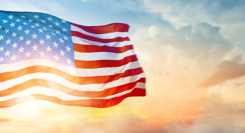 Patriotic holiday. The USA are celebrating 4th of July. American flag on sunset background. Patriotic holiday. The USA are celebrating 4th of July. American flag on sunset background