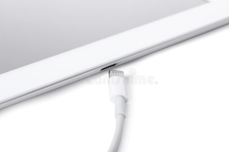 USB Cable with Lightning Connector and Tablet on White Background Stock