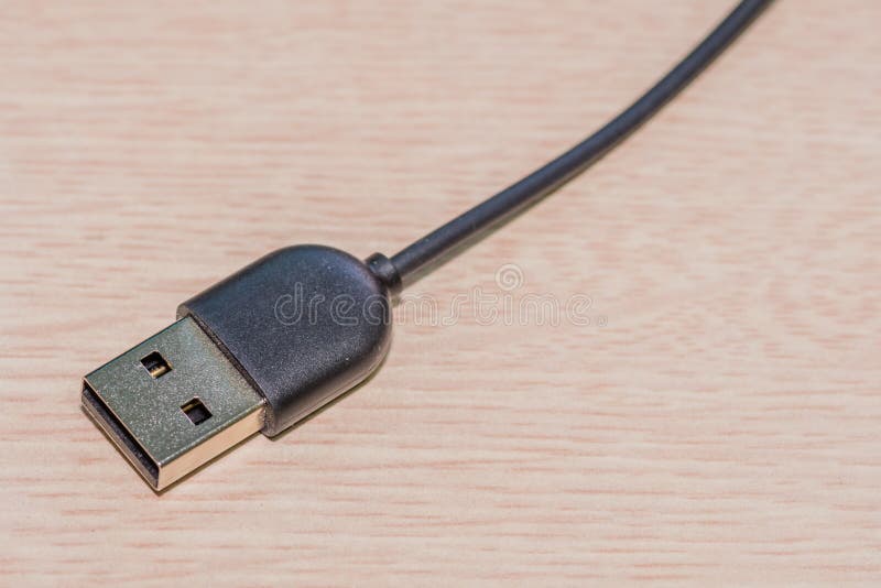 USB charging cord on wood grain background. USB charging cord on wood grain background