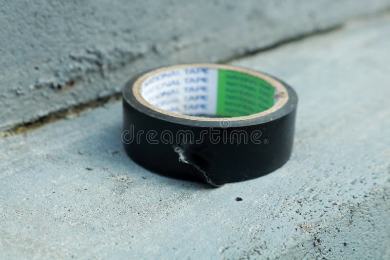Used Black Duct Tape that Has Been Used on a Gray Background Stock