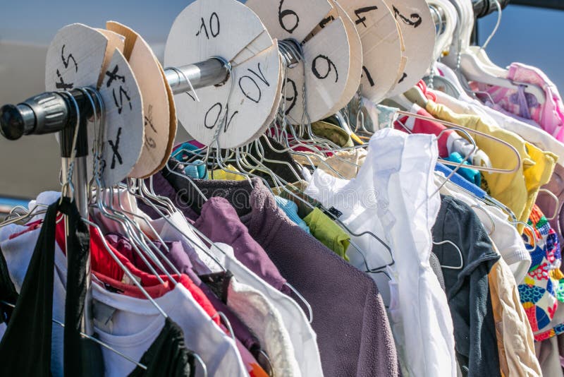 Used child and baby clothes displayed per size on rack stock image Used child and baby clothes displayed per size on rack stock image