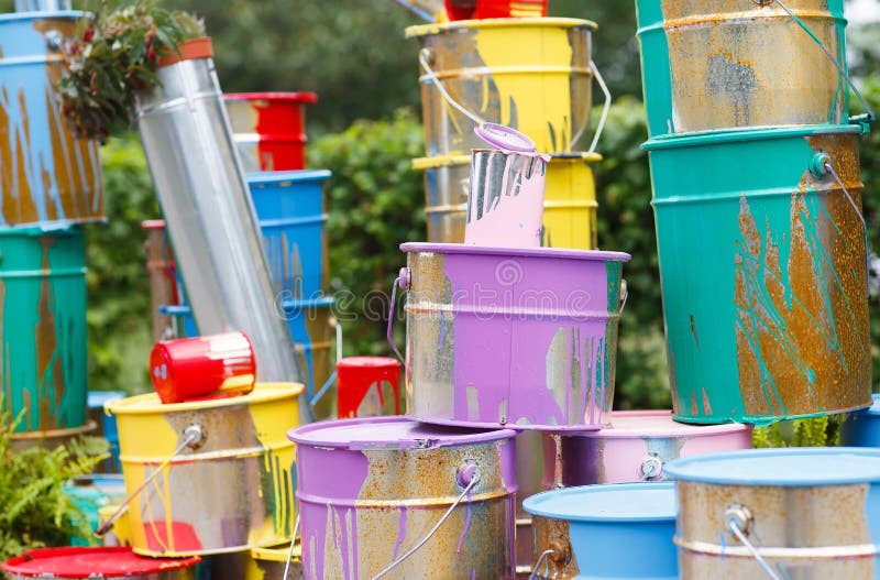 The Used Paint Cans. Many Multicolored Buckets with Traces of Paint on