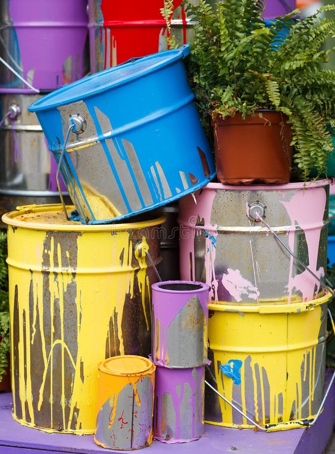 The Used Paint Cans. Many Multicolored Buckets with Traces of Paint on