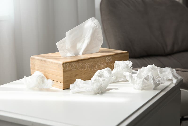 Used paper tissues and wooden holder on table