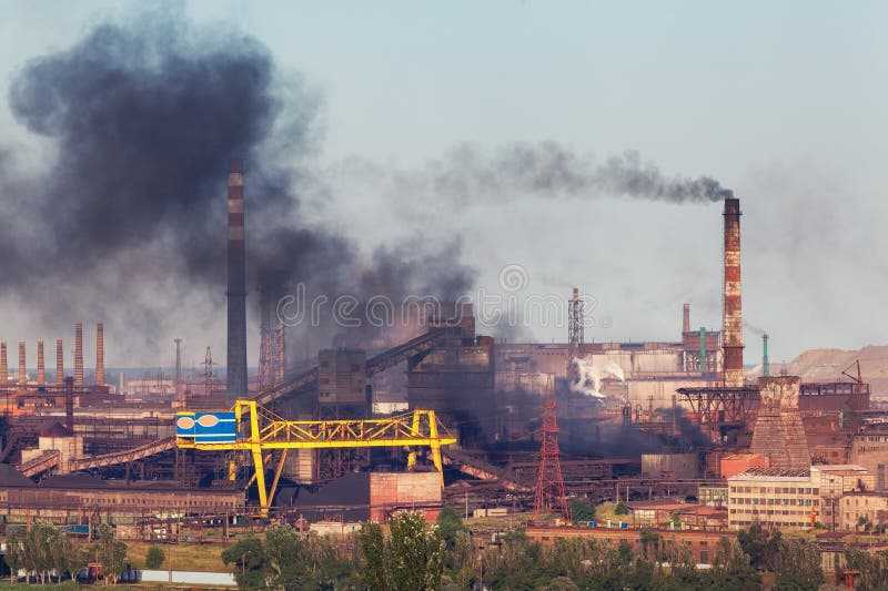 Usine en acier avec le brouillard enfumé au coucher du soleil Tuyaux avec de la fumée noire image stock Usine en acier avec le brouillard enfumé au coucher du soleil Tuyaux avec de la fumée noire image stock