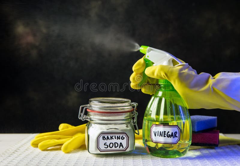 Using baking soda Sodium bicarbonate and white vinegar for home cleaning. White vinegar in spray bottle and baking soda in glass j