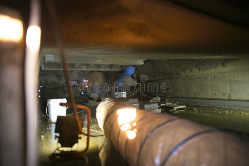 Using exhausting ventilation system fan safety precaution while rope access miners commencing oxy torch cutting metal hot work in royalty free stock photography Using exhausting ventilation system fan safety precaution while rope access miners commencing oxy torch cutting metal hot work in royalty free stock photography