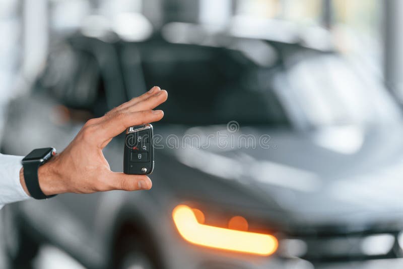 Using the Keys Remote Controller. Young Man in White Clothes is in the