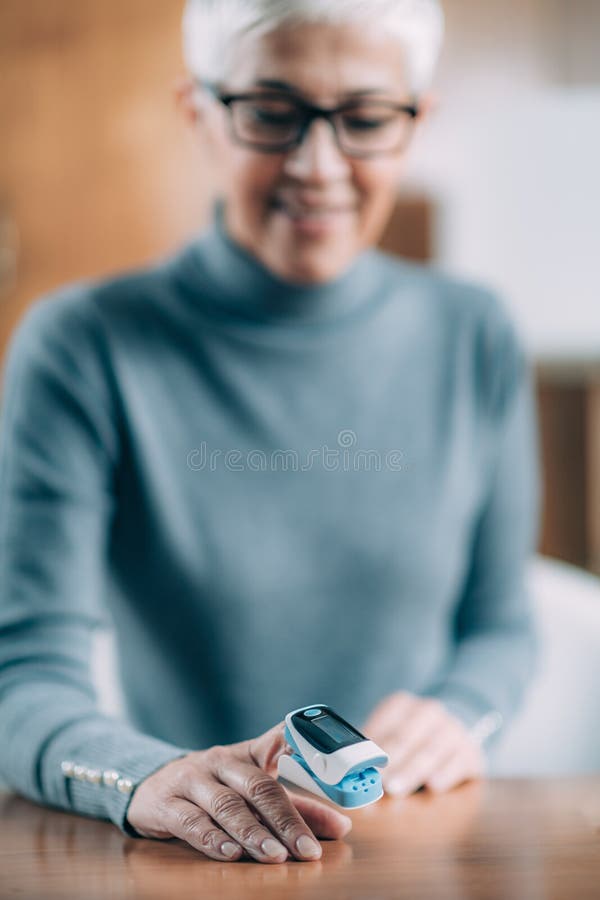 Using Pulse Oximeter at Home To Test Oxygen Level in Blood Stock Image