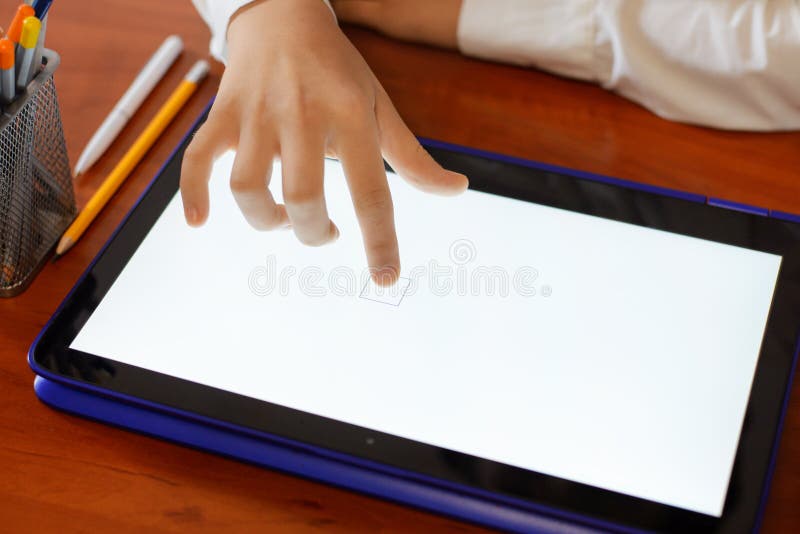 Primary School Girl Using Tablet Computer in Classroom Stock Photo