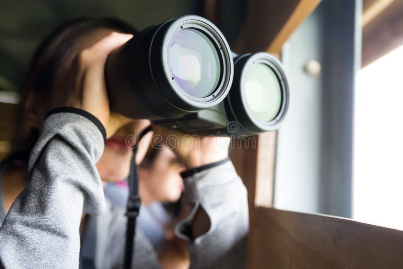 Uso asiatico della donna del binocolo per il birdwatching fotografia stock libera da diritti Uso asiatico della donna del binocolo per il birdwatching fotografia stock libera da diritti