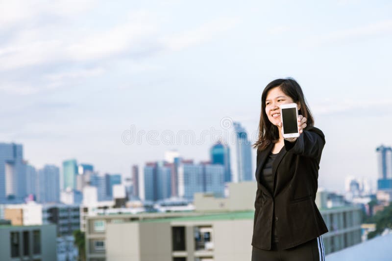 Uso asiático da mulher do negócio do telefone celular e mostrar da tela fotografia de stock royalty free Uso asiático da mulher do negócio do telefone celular e mostrar da tela fotografia de stock royalty free