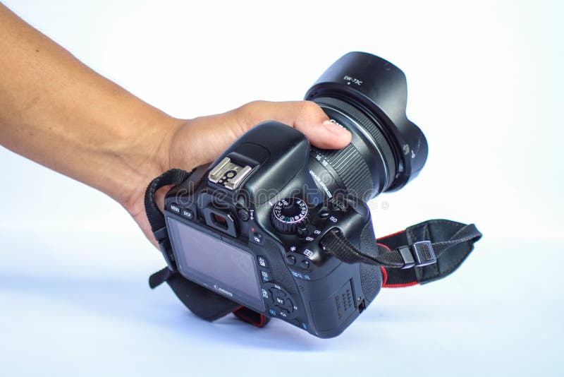 CAMARINES SUR, PHILIPPINES - OCT 28, 2018: A photo of a hand holding a used Canon EOS 550D, also known as the Rebel T2i or the Kiss X4 Digital with a Canon 10-18 mm wide angle lens attached. CAMARINES SUR, PHILIPPINES - OCT 28, 2018: A photo of a hand holding a used Canon EOS 550D, also known as the Rebel T2i or the Kiss X4 Digital with a Canon 10-18 mm wide angle lens attached