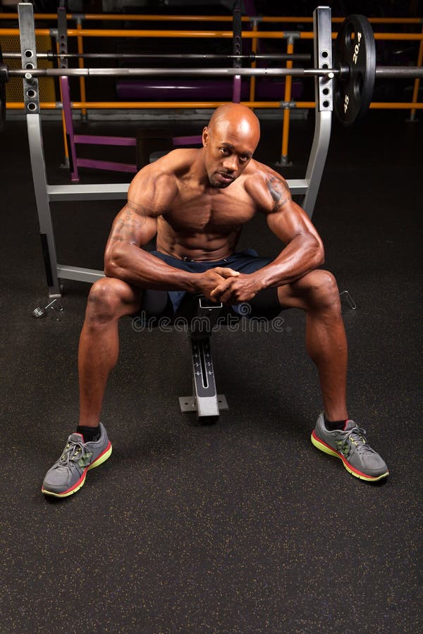 Weight lifter sitting at the bench press about to lift a barbell. Weight lifter sitting at the bench press about to lift a barbell.